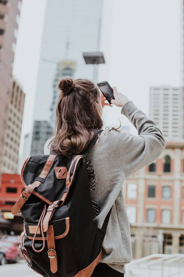 An image of a teenager taking a photo with her phone representing Dare 2 Share's blog titled Youth Group Games With a Purpose.