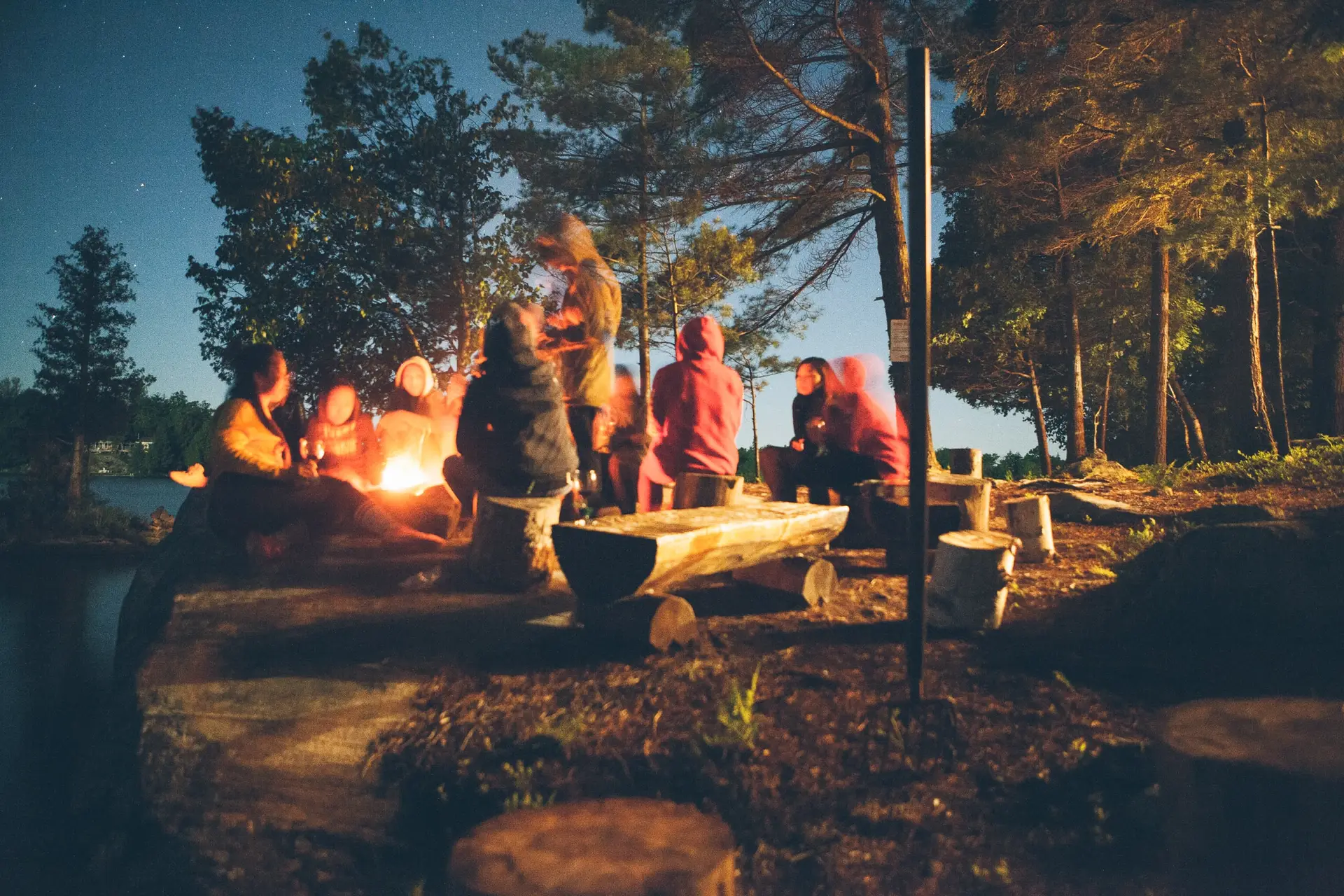 Image of a group of friends around a bonfire representing Dare 2 Share's post about fall church outreach ideas.