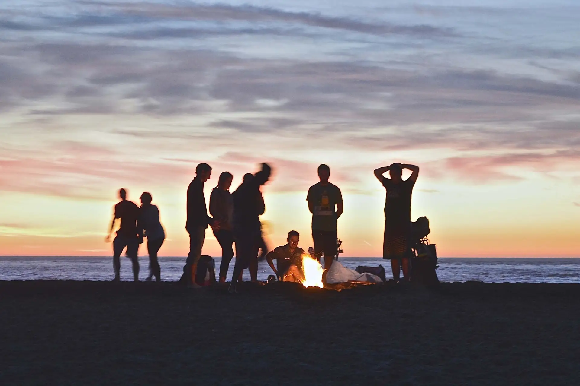 5 High-Impact Summer Youth Events shown by a camp fire on the beach