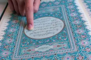 Picture of person reading a passage from the Muslim Koran