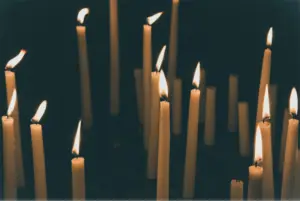 Picture of multiple lit candles against a dark background