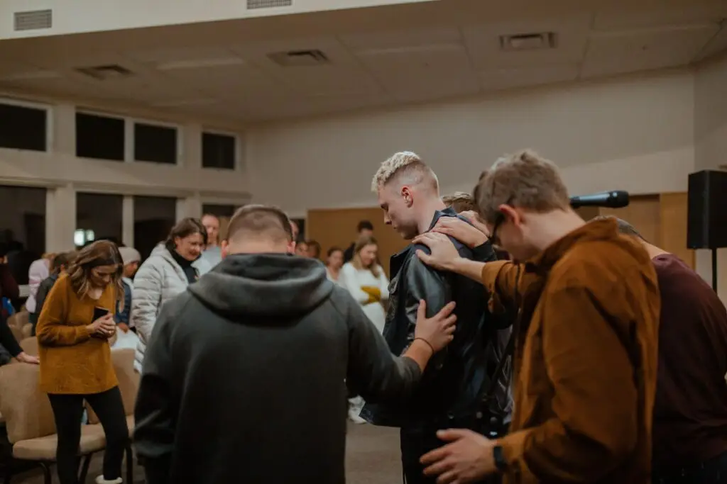 Students praying over each other representing Dare 2 Share's blog on 4 ways to pray for a successful, evangelistic youth group.