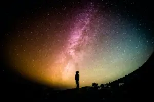 Silhouette of a person looking at a galaxy above