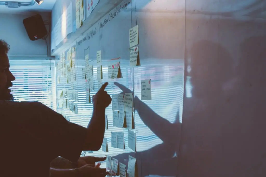 Image of man in front of a white board filled with post it notes representing Dare 2 Share's blog How to Cast a Bold Vision for Your Youth Ministry: 5 Steps to Unlocking Its Potential