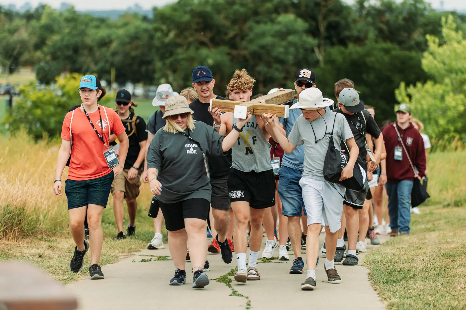 Students carrying cross up Columbine memorial