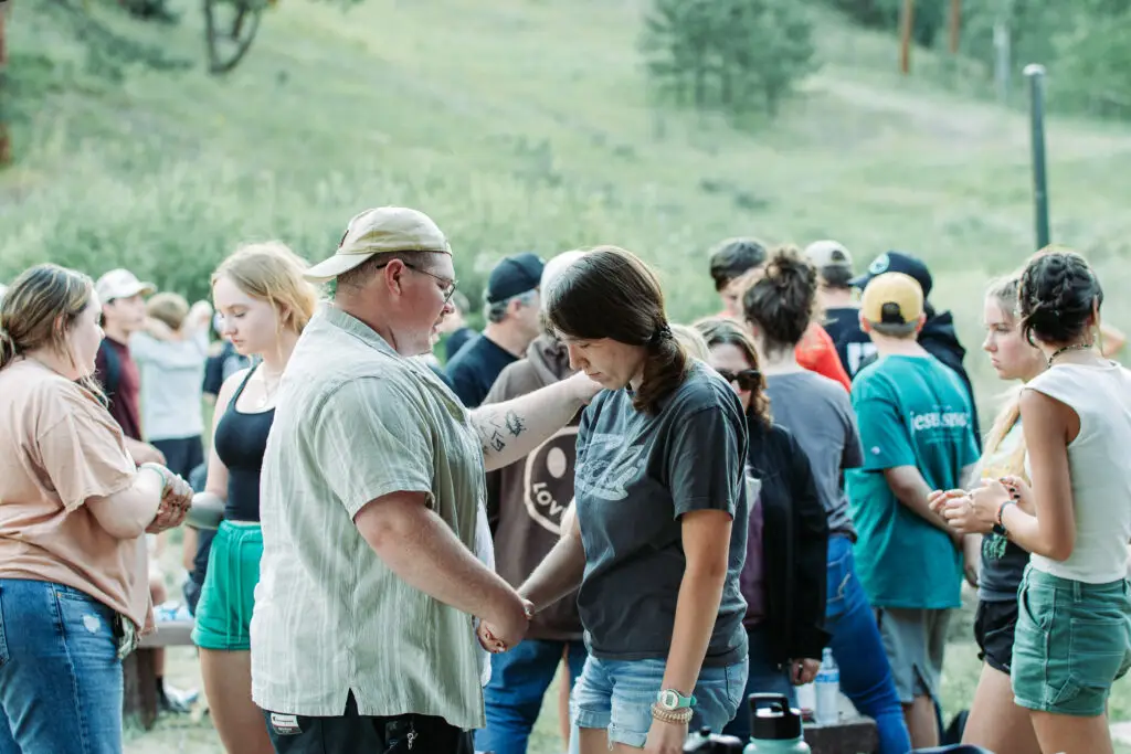 Leader praying over student after commissioning her