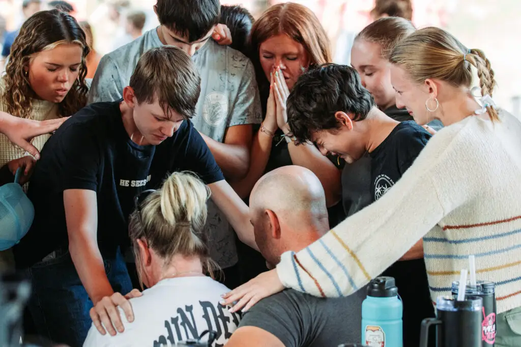 Youth group praying over one another