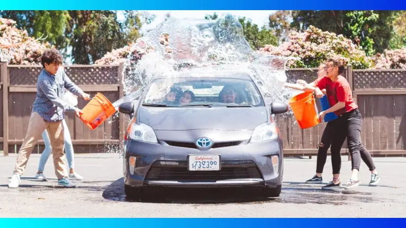 Image of teens splashing a car with water