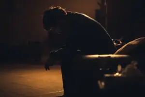 a man sitting on a park bench alone to signify Shepherding through tragedy