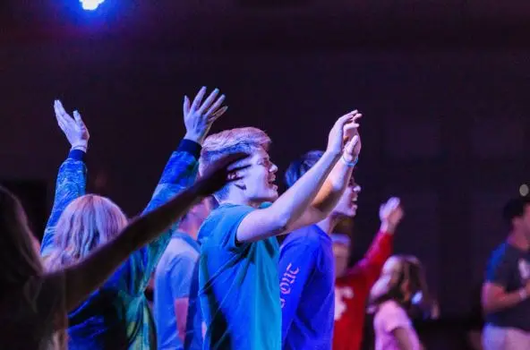 Teenage students worshipping at a Christian youth conference