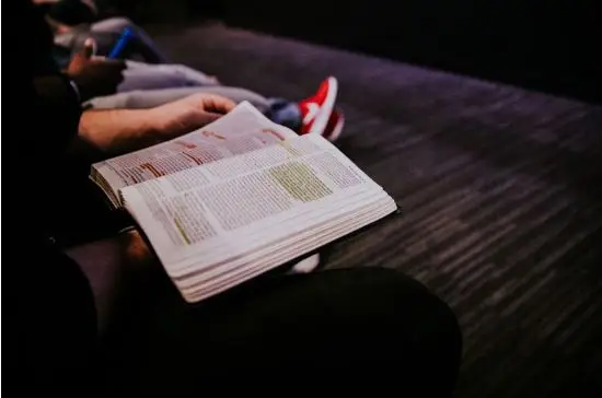 Picture of an open Bible being studied at a youth conference.