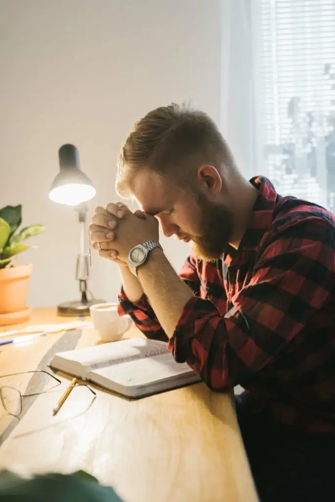 An image of a man praying and reading the bible, representing Dare 2 Share's blog titled The Power of a Strong Prayer Life on Youth Ministry.