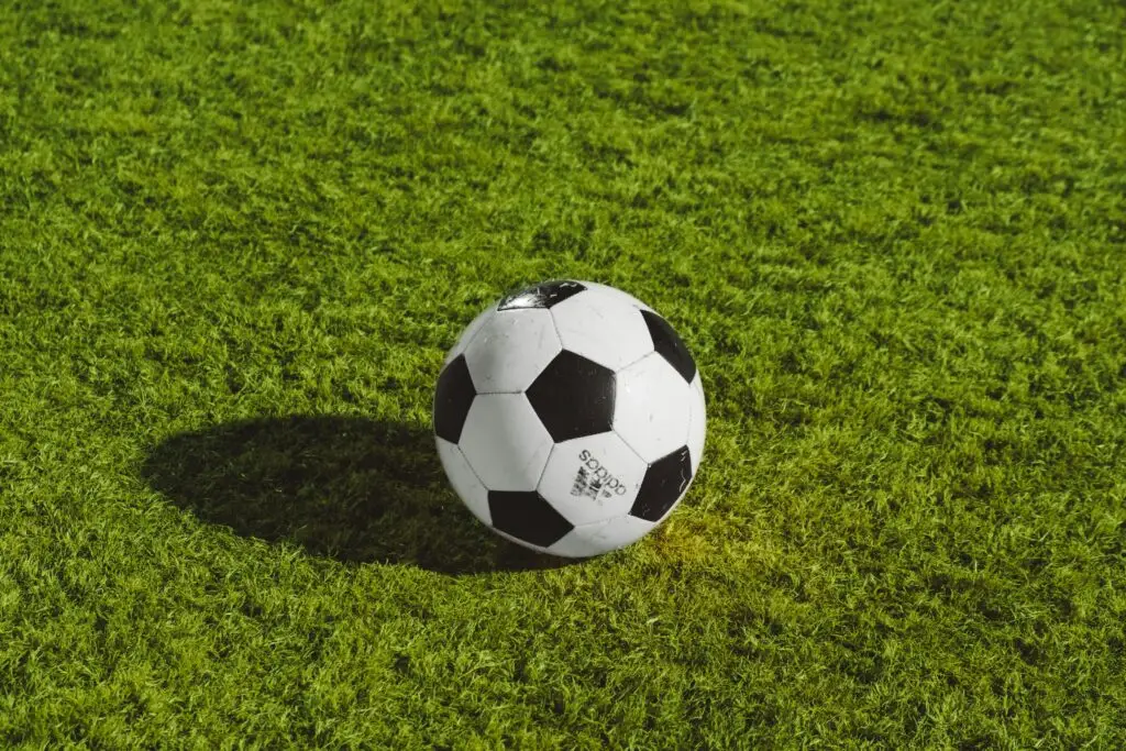 An image of a soccer play on a field of grass representing Dare 2 Share's blog titled Top 4 Big Youth Group Games