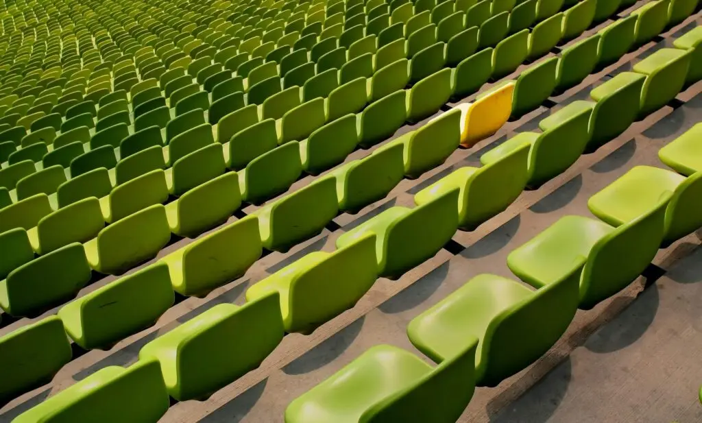 An image of lots of green chairs with one yellow chair in the middle of them representing Dare 2 Share's blog titled Top 5 Games for Small Youth Groups