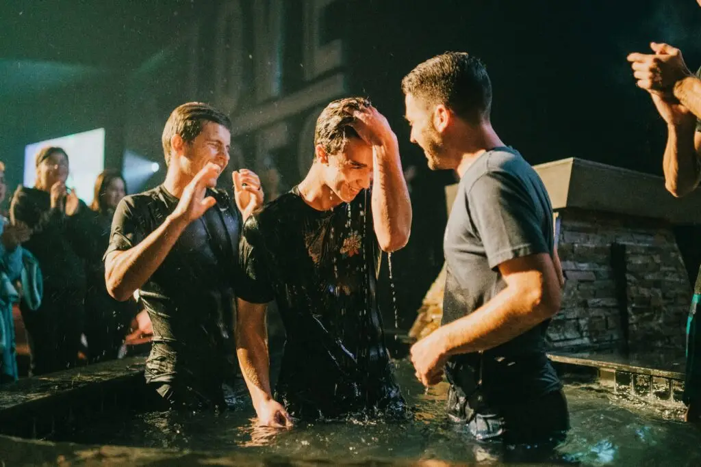 An image of a teenage boy being baptized surrounded by friends. This image is used for Dare 2 Share's Ultimate Guide to being a Youth Pastor.